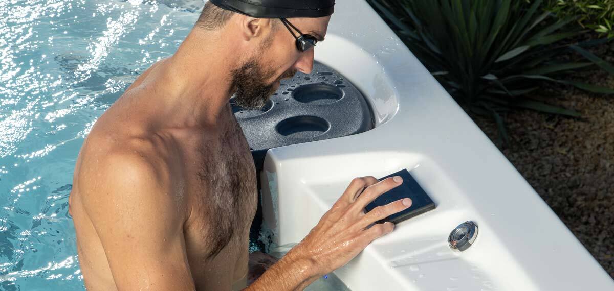 Michael Phelps using the touchscreen control panel on a swim spa.